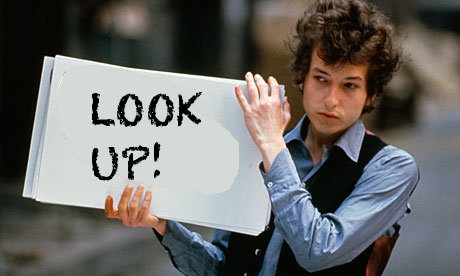 Bob Dylan holding sign saying Look up!